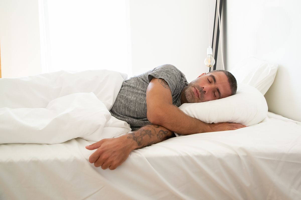 Hombre durmiendo en colchón para posición preferida